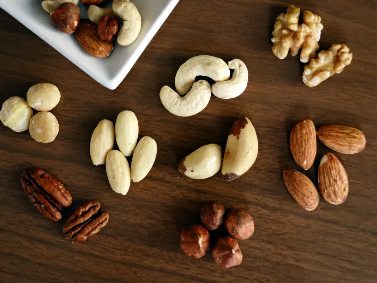 Walnüsse, Mandeln, Cashews, Pekannüsse und Haselnüsse auf einem dunklen Holztisch